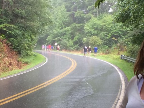 Middle-aged group walking on country road in the rain