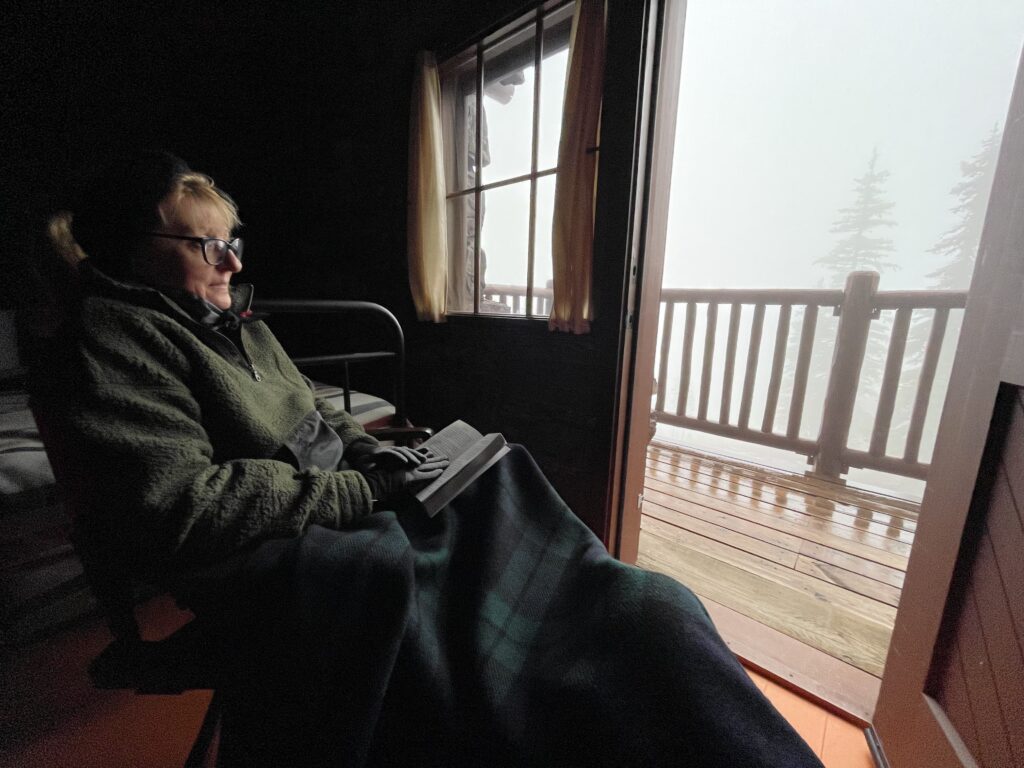 Woman sitting in cabin bundled up