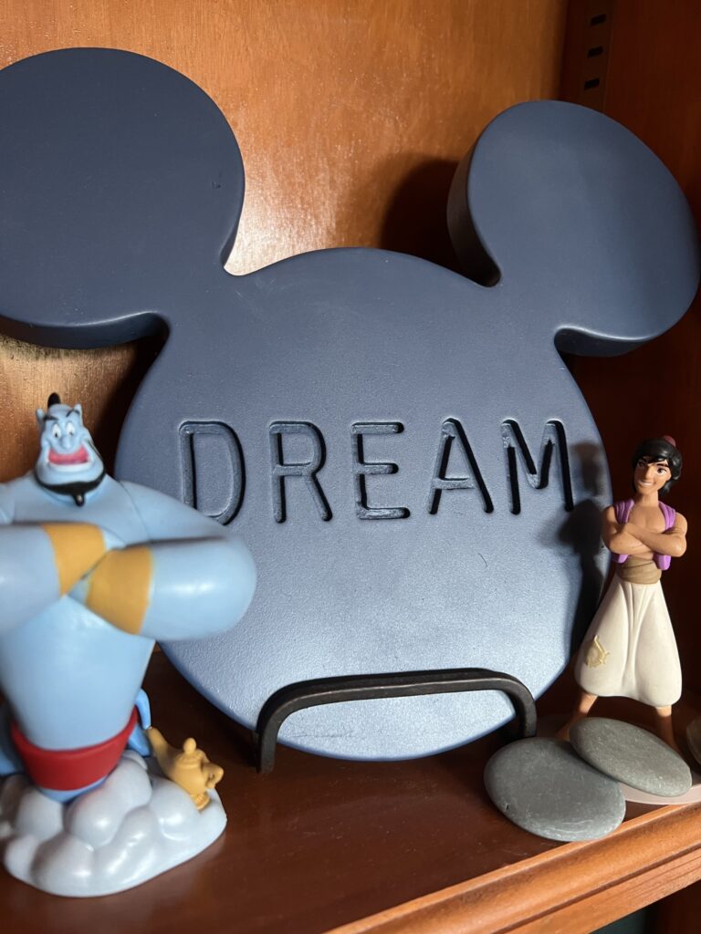 Disney toy characters on a book shelf