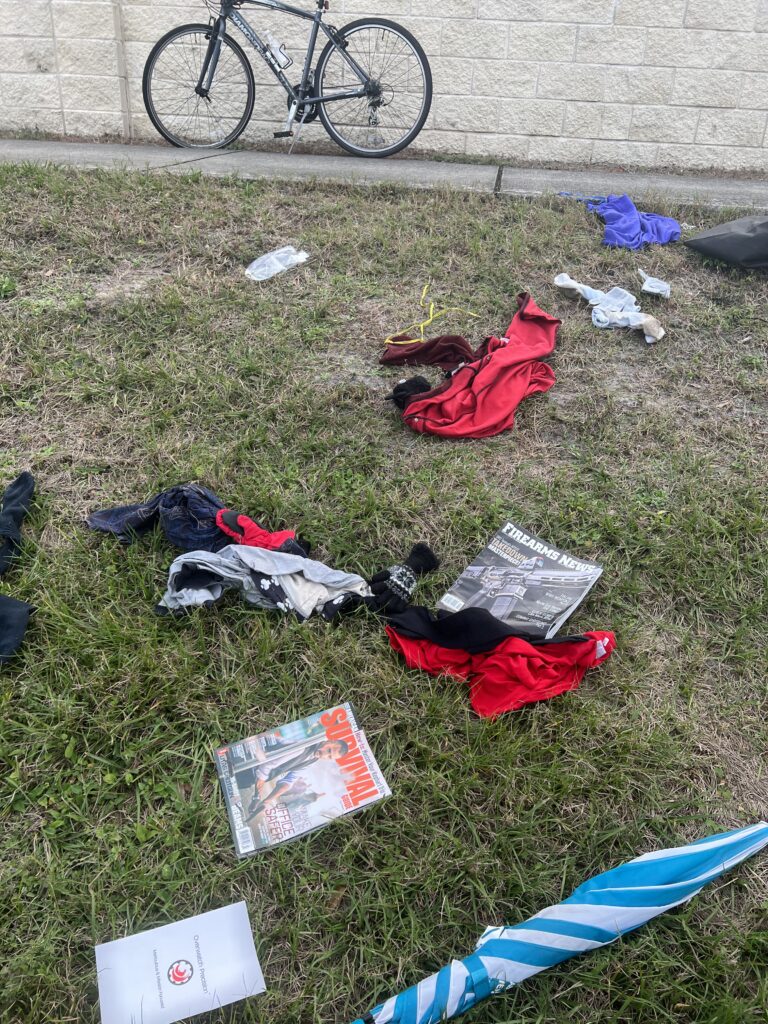 roadside homeless persons belongings strewn across ground