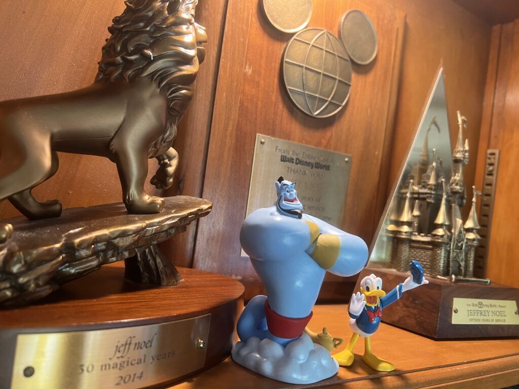 Disney trophies and Disney character toys on a bookshelf