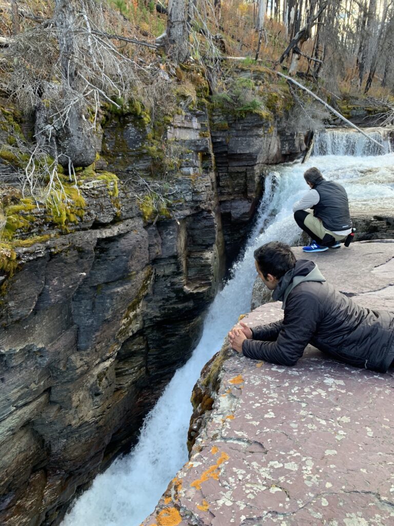 two man watching a waterfall